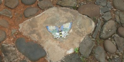 Stepping stone dengan ornamen keramik motif kupu-kupu.