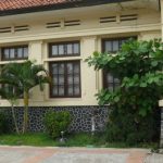 pohon menutupi fasad bangunan.