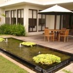 peletakan gazebo berupa payung di halaman belakang rumah.