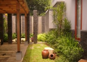 Pergola di atas carport rumah dengan material kayu.
