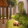 Pergola di atas carport rumah dengan material kayu.